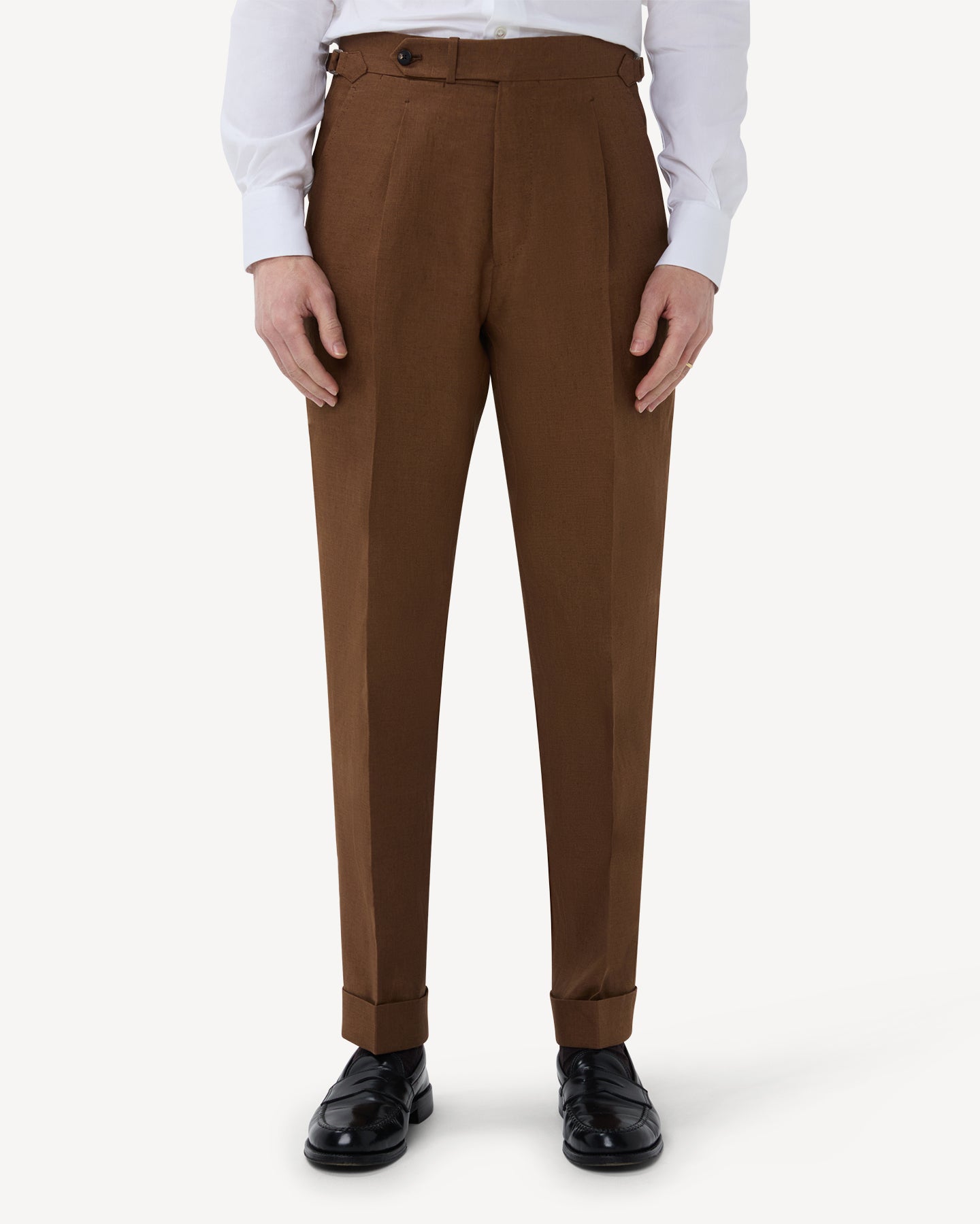 The front of dark tan linen trousers with single pleats and side adjusters