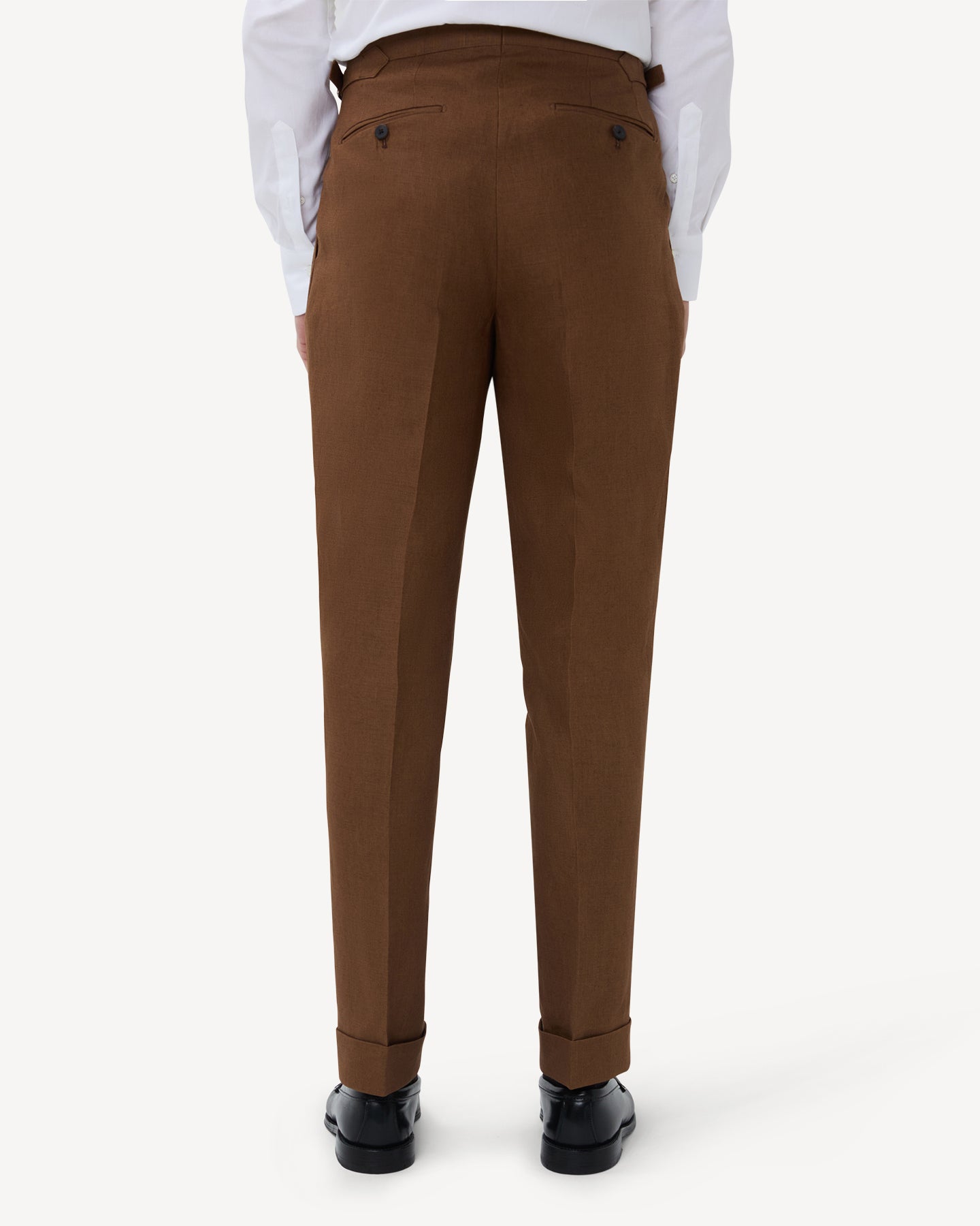 The back of dark tan linen trousers with single pleats and side adjusters