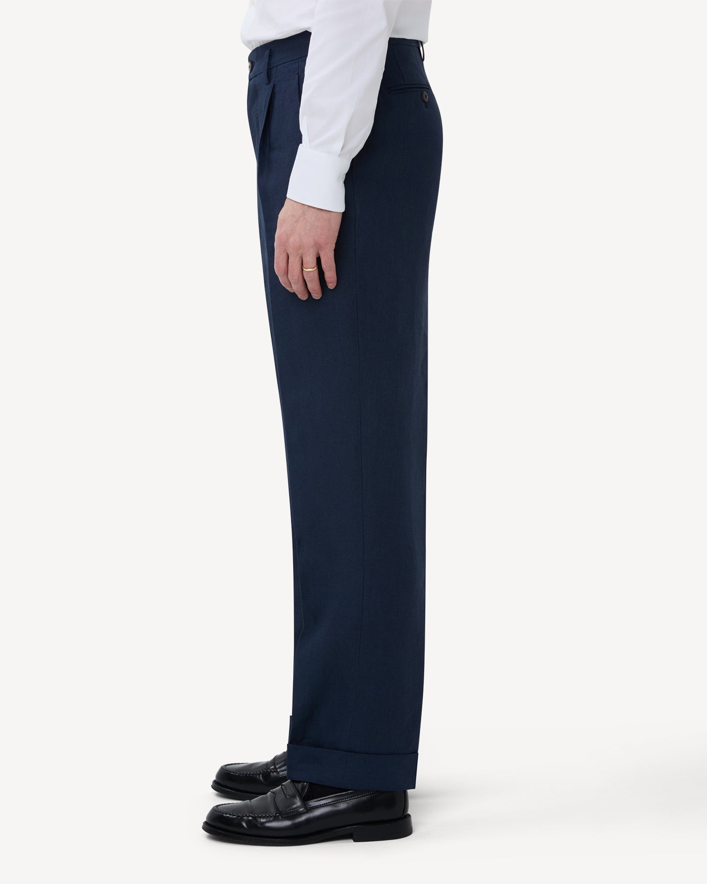 The side of navy linen trousers with double pleats and belt loops