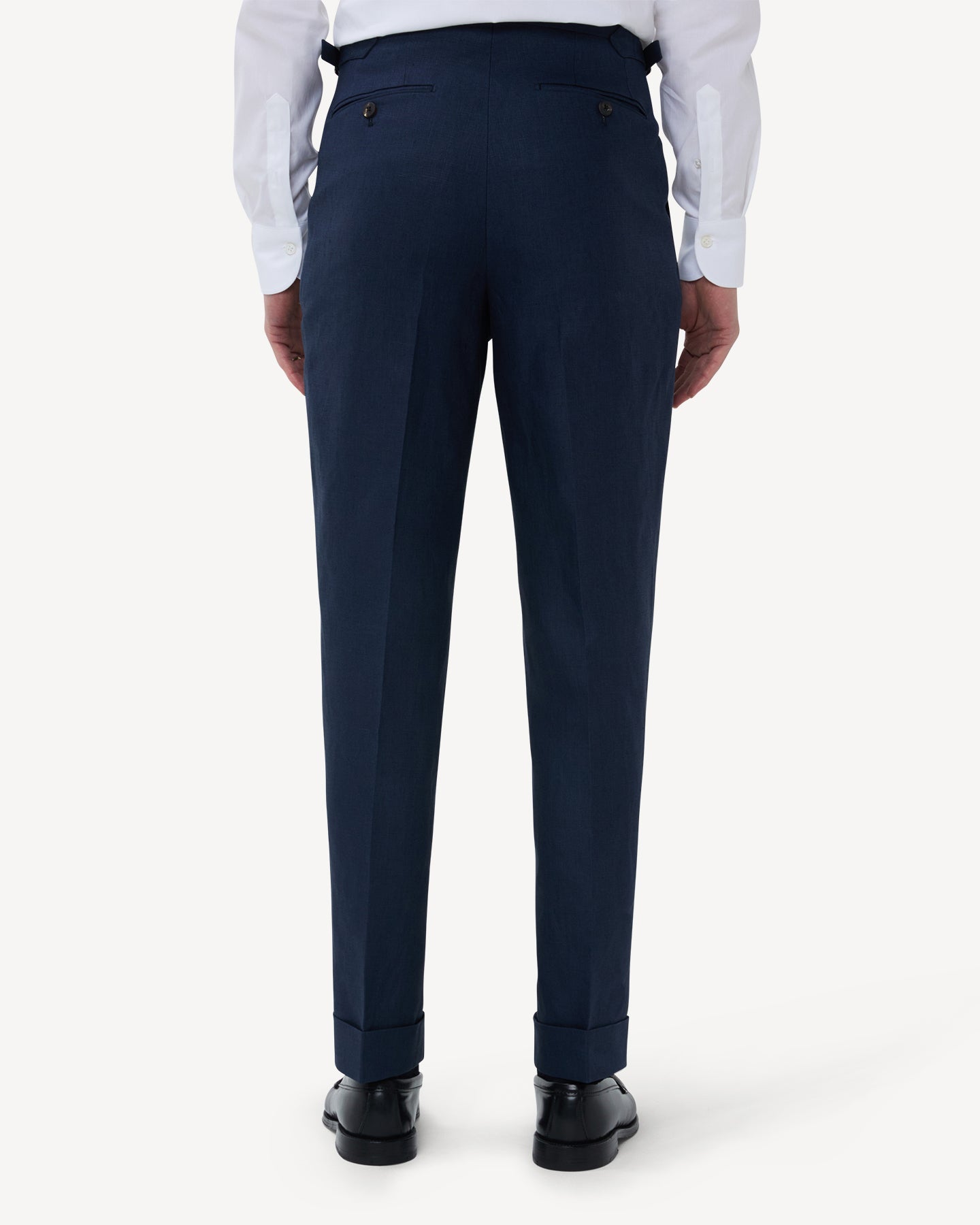 The back of navy linen trousers with single pleats and side adjusters