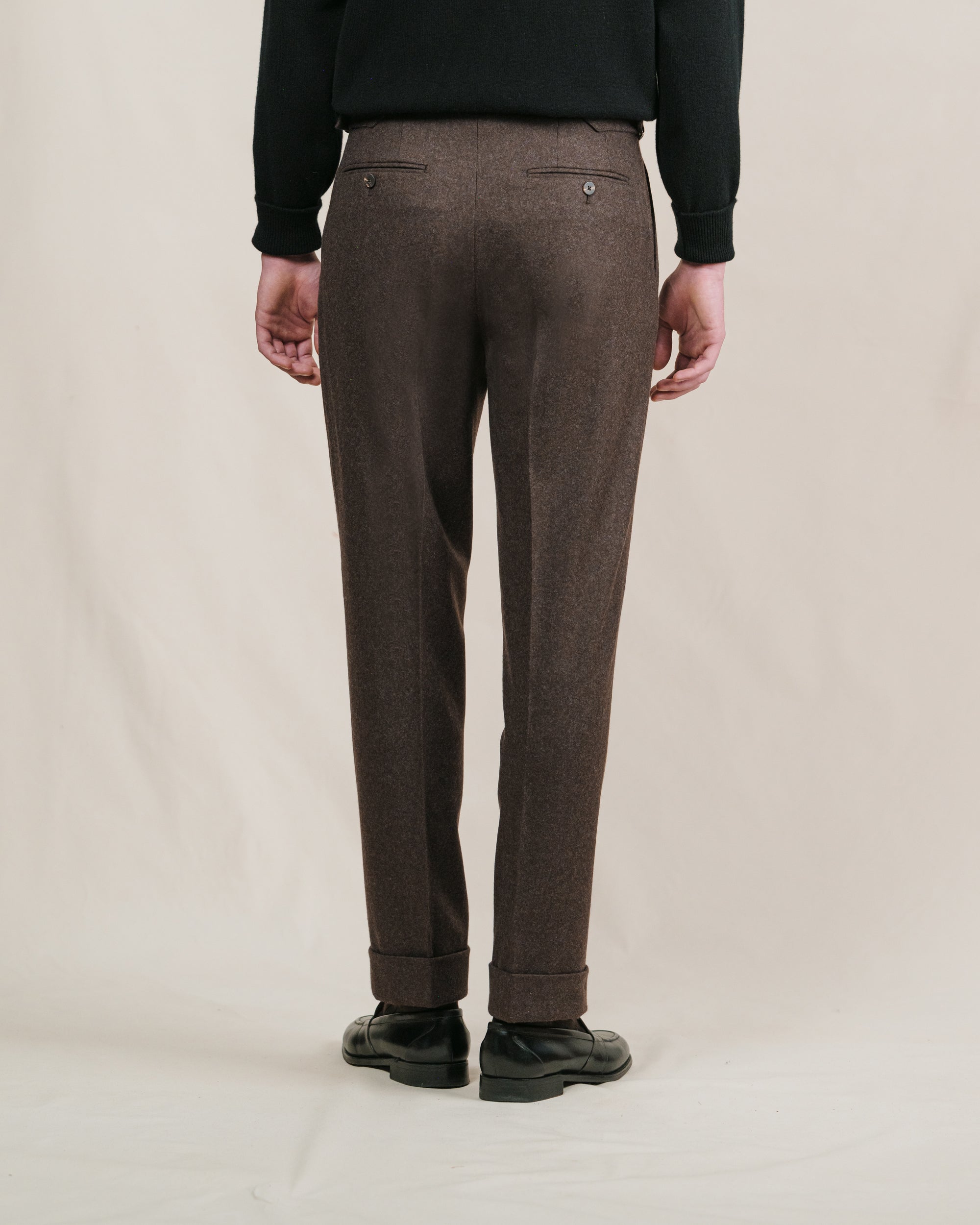 A man wearing a pair of brown flannel trousers