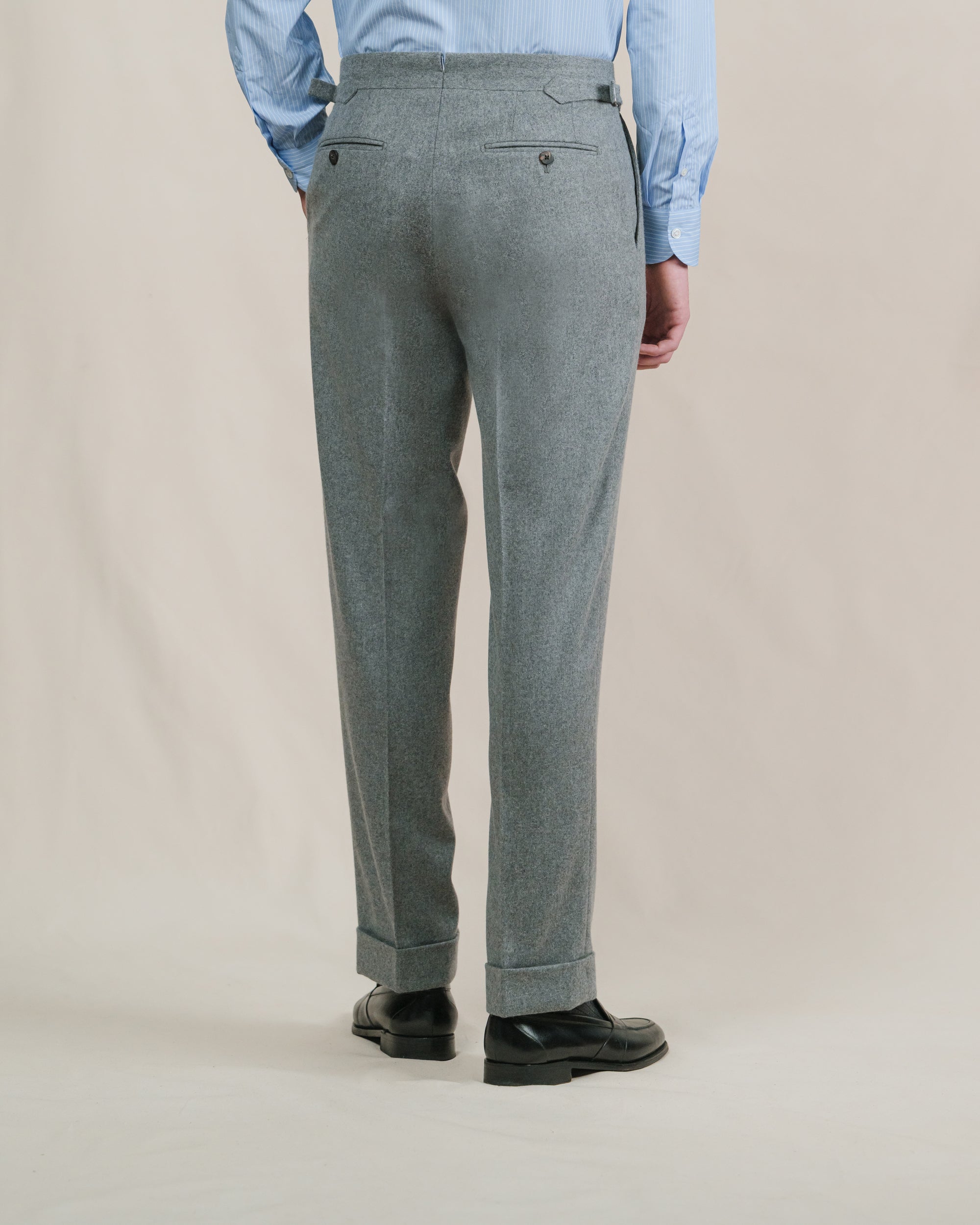 Man wearing a pair of light grey flannel trousers