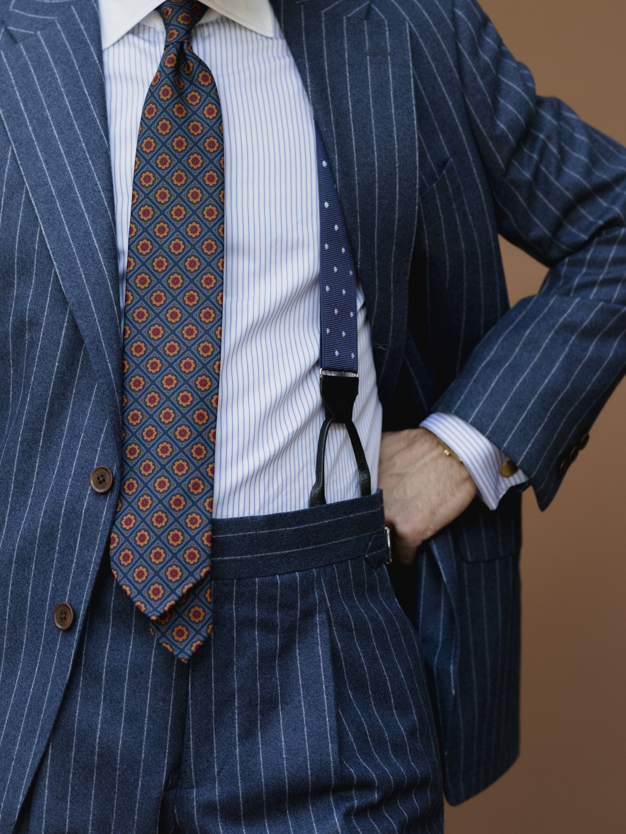 Man wearing a chalk striped suit combined with striped contrast collar shirt and ancient madder tie